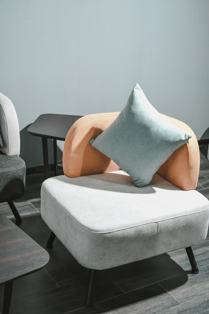 Photo by Pesce Huang white and brown throw pillow on white sofa chair